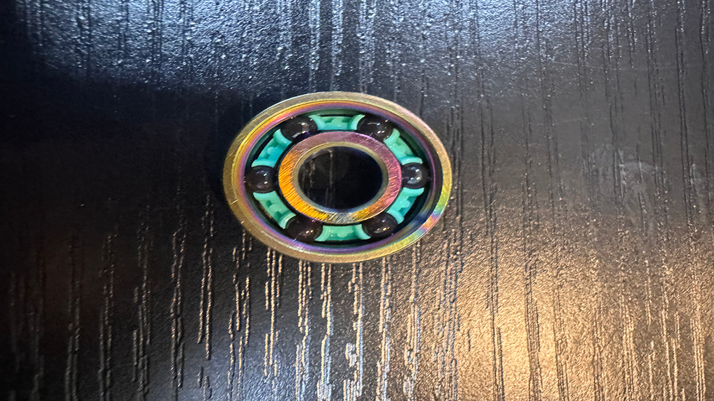 High-quality ceramic 6-ball bearing with the shield removed, highlighting the larger ball bearings for reduced friction and increased speed. Beagle Bearings innovation at its finest!